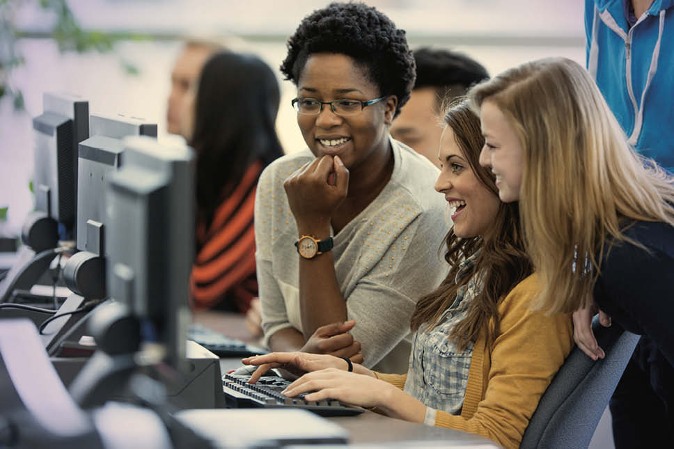 group of young women on a desktop computer