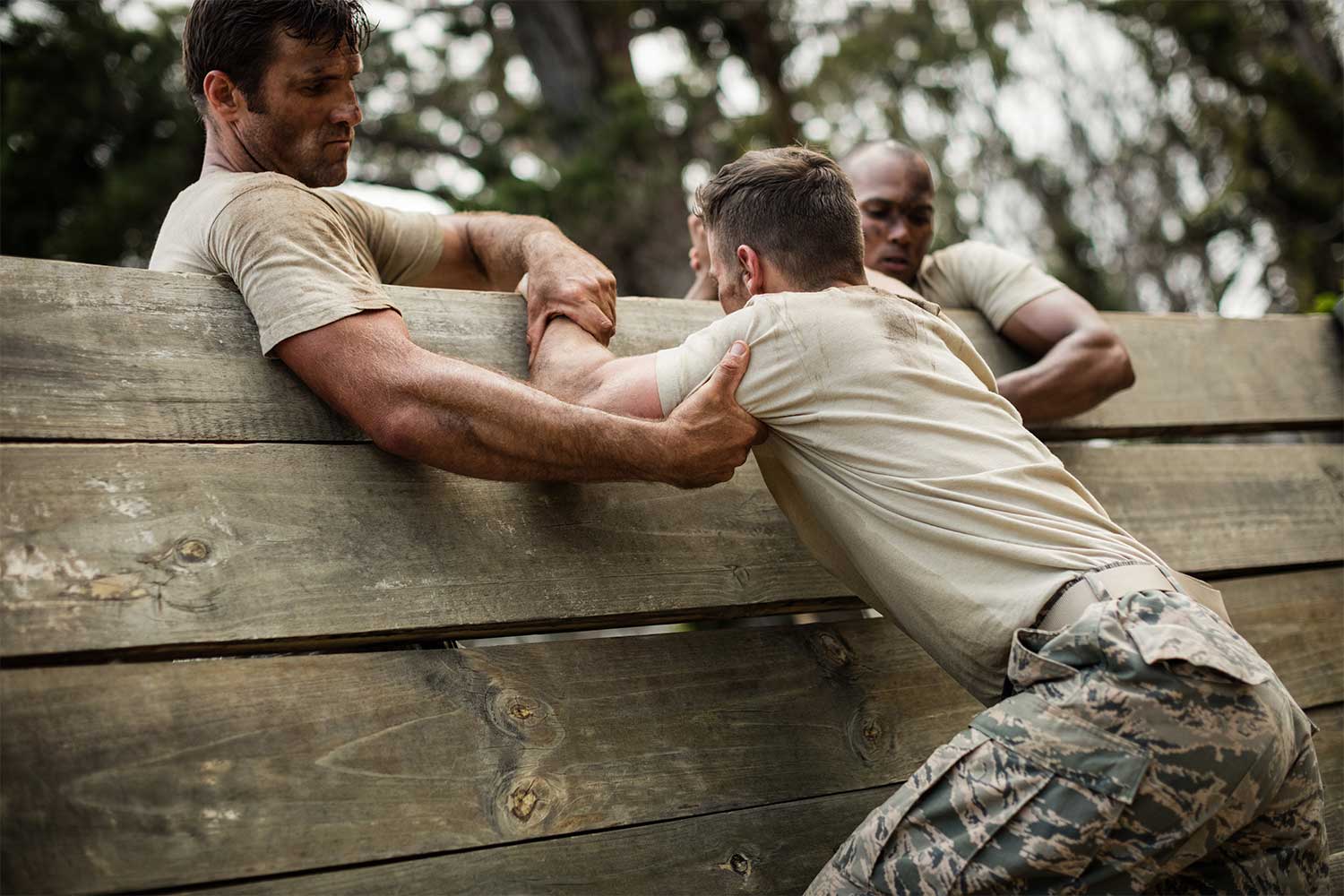 Soldiers helping each other over wall