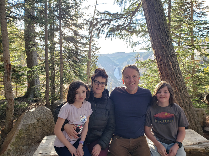 Dr, Foster posing for a photo with his family in the woods