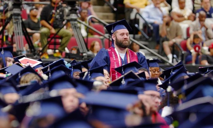 Elijah in the crowd of graduates at commencement