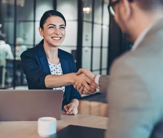 Woman on laptop shaking hands