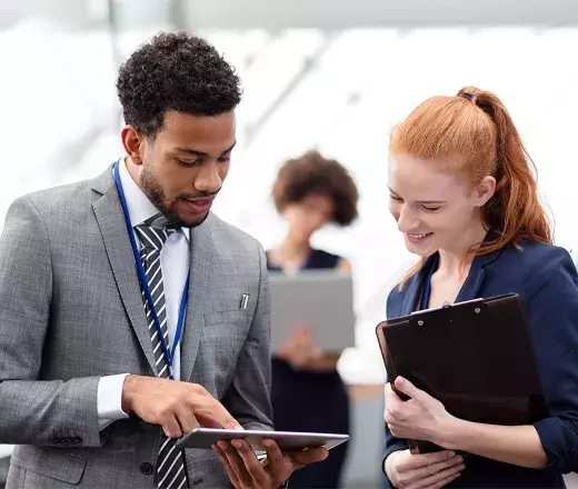 Guy talking to a lady with tablet on hand