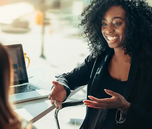 woman smiling and talking with coworker