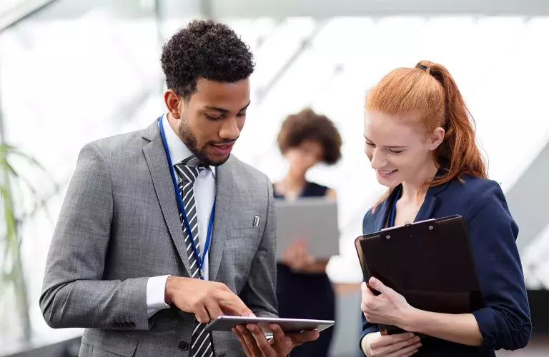 Guy talking to lady with tablet on hand