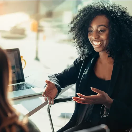 woman smiling and talking with coworker