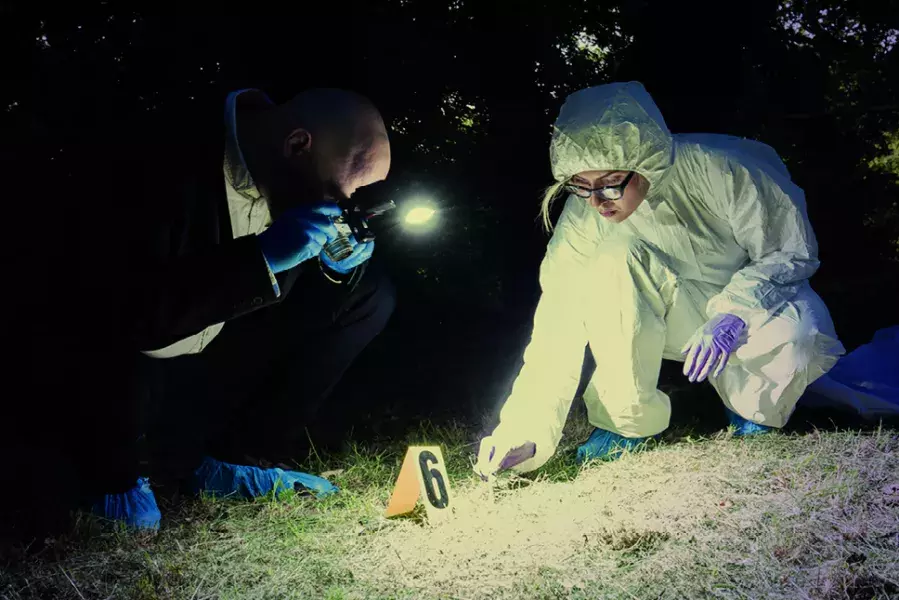 crime scene investigators looking at evidence