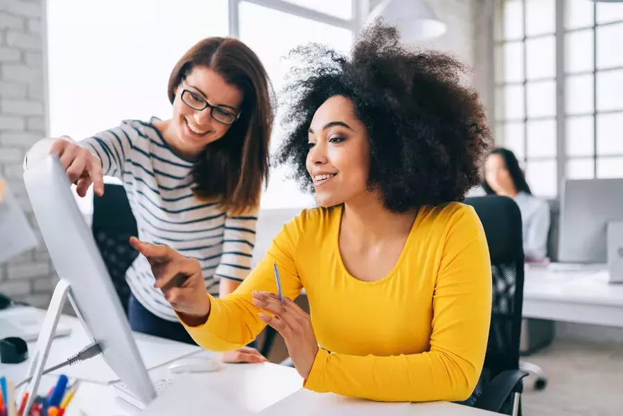 women discussing in front of computer