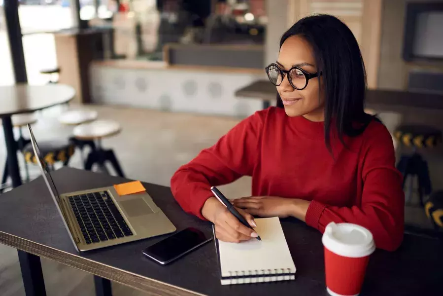 Lady in front of laptop taking notes