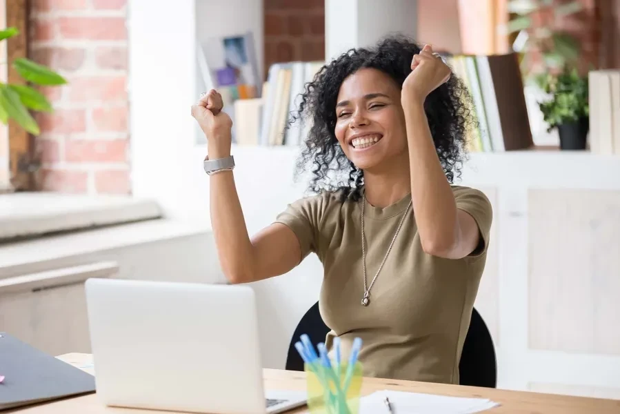 lady on laptop raising hands