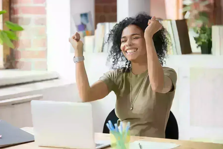 lady on laptop raising hands