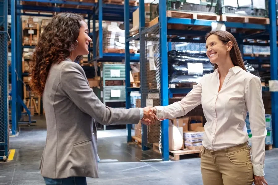Ladies in warehouse shaking hands