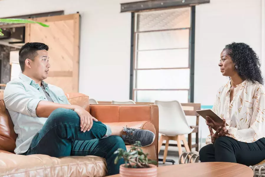 Man sitting in couch talking to a professional