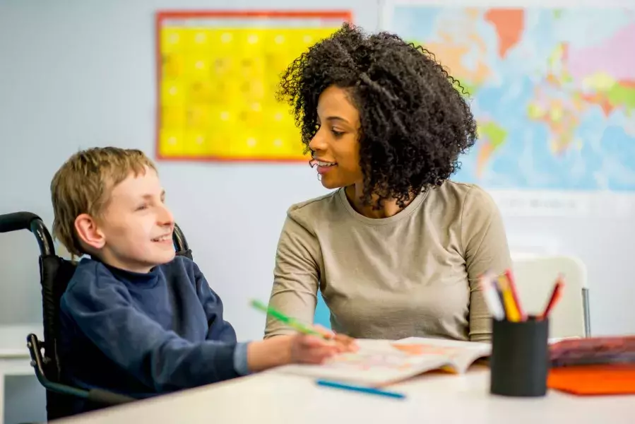 lady teaching a disabled boy