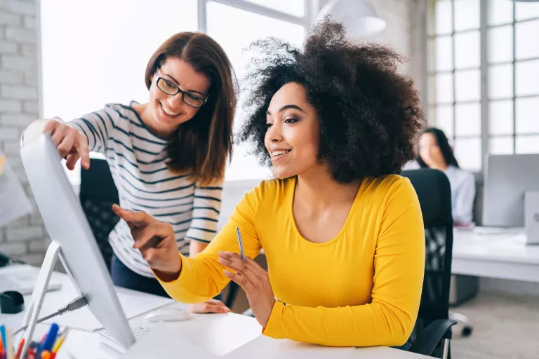 women discussing in front of computer