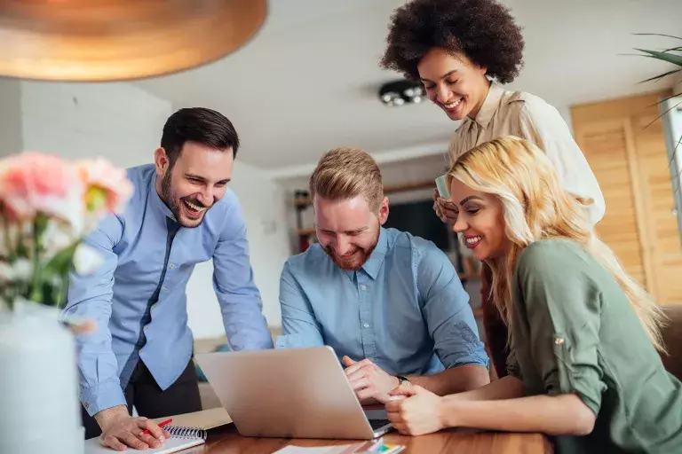 Professionals discussing in front of a laptop