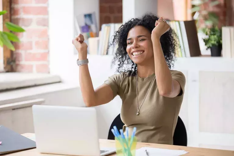 lady on laptop raising hands