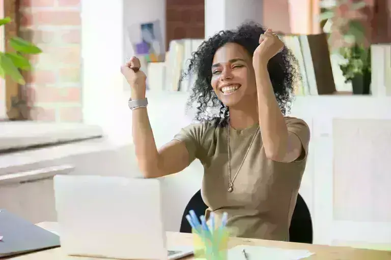 lady on laptop raising hands