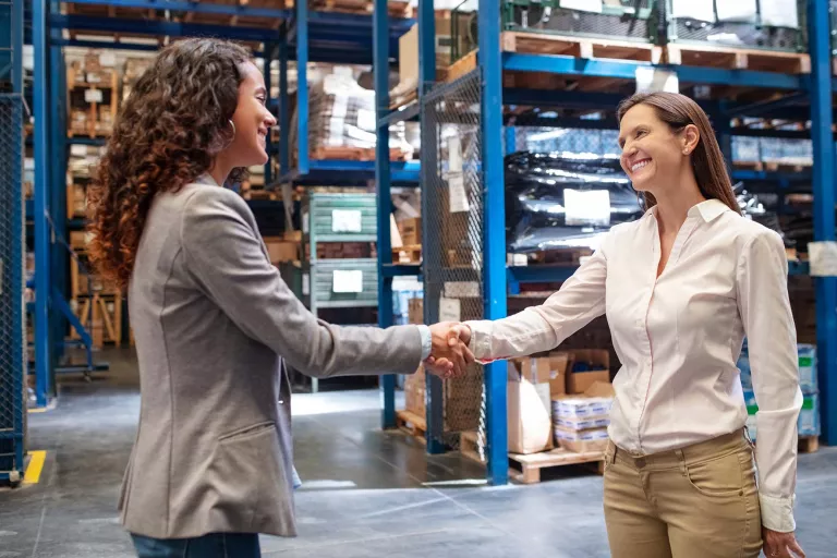 Ladies in warehouse shaking hands