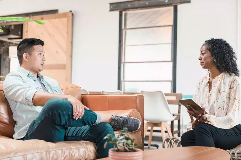 Man sitting in couch talking to a professional