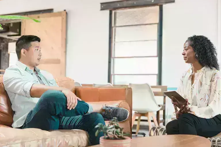 Man sitting in couch talking to a professional