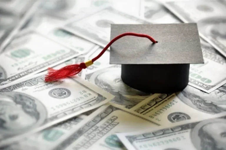 graduation cap on money