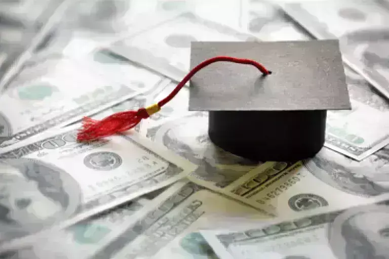 graduation cap on money