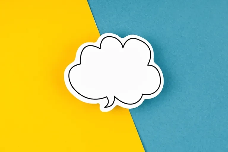 a cutout of a conversation bubble on a solid diagonal color split background of yellow and blue